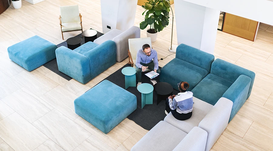 Vista rialzata di un open space con aree collaborative e sedute modulari