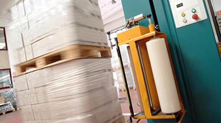 Macchina avvolgitrice con film estensibile automatico durante l’imballaggio di un pallet